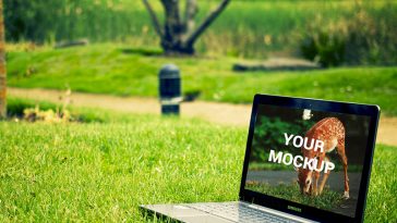 laptop on green grass mockup psd notebook